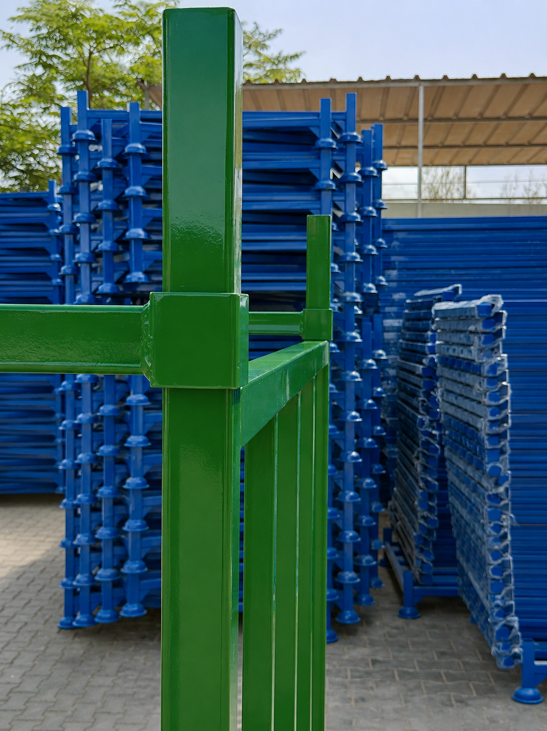 Green steel pallet with finished blue pallets behind it